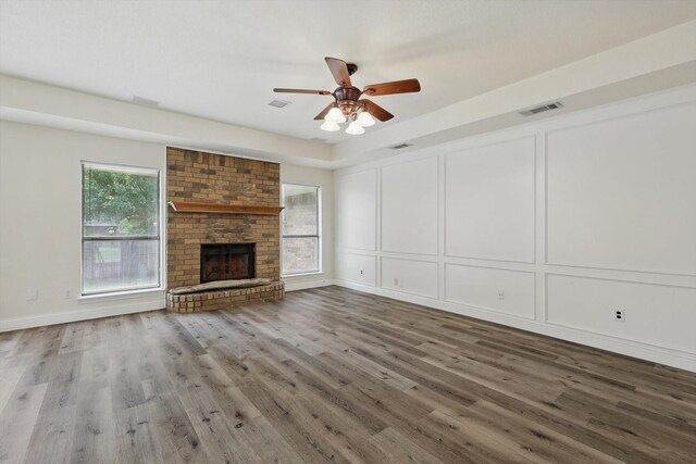7616 Teresa Ct, North Richland Hills, TX 76182 - unfurnished living room with a decorative wall, a fireplace, a ceiling fan, and wood finished floors