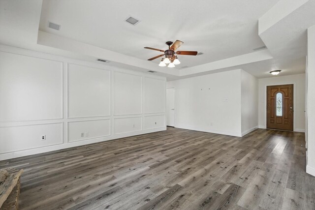 7616 Teresa Ct, North Richland Hills, TX 76182 - unfurnished living room with a raised ceiling, ceiling fan, a decorative wall, wood finished floors, and baseboards