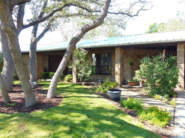 135 Lakeview, Brady, TX 76825 - view of front facade with a front lawn, brick siding, and metal roof