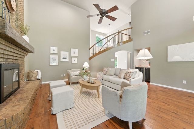 1610 Ottinger Rd, Keller, TX 76262 - living area with high vaulted ceiling, a fireplace, a ceiling fan, wood finished floors, and arched walkways