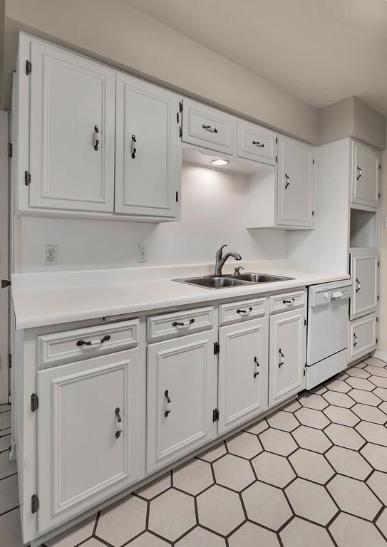 2832 Wooded Acres Dr, Waco, TX 76710 - kitchen with dishwasher, a sink, white cabinetry, and light countertops