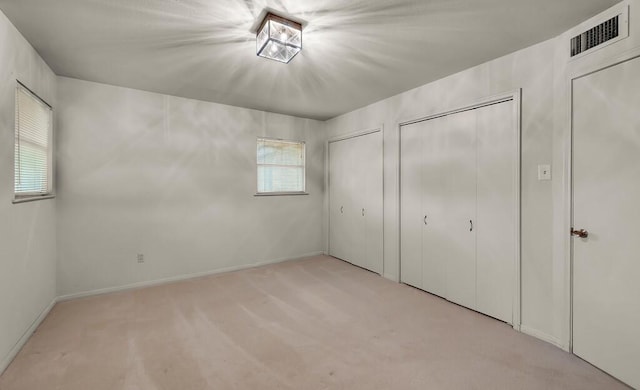 2832 Wooded Acres Dr, Waco, TX 76710 - unfurnished bedroom featuring multiple closets, carpet floors, and baseboards