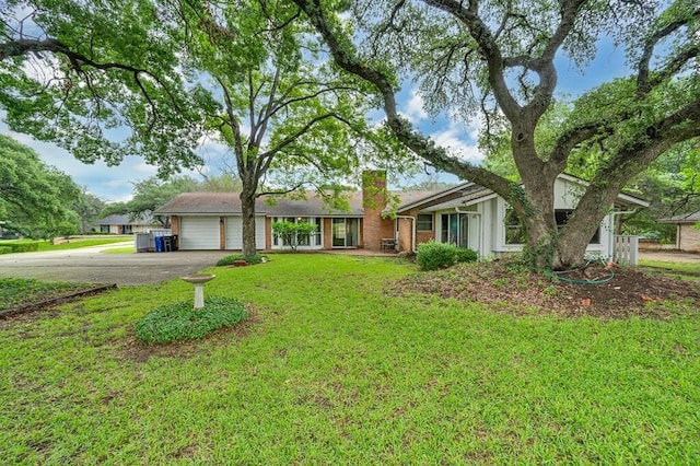 2832 Wooded Acres Dr, Waco, TX 76710 - view of front of house with a chimney, a garage, concrete driveway, and a front lawn