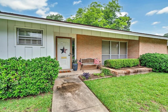 2832 Wooded Acres Dr, Waco, TX 76710 - doorway to property featuring a porch, board and batten siding, brick siding, and a lawn