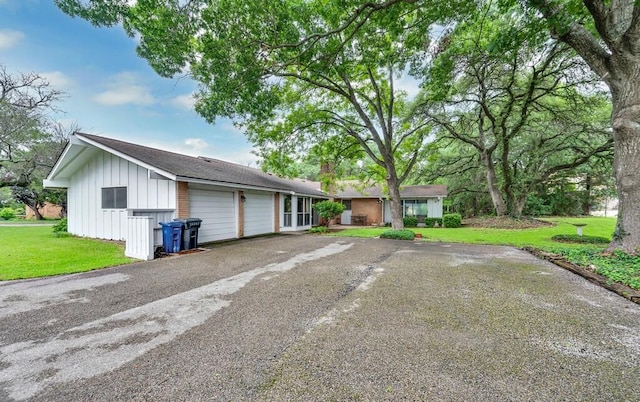 2832 Wooded Acres Dr, Waco, TX 76710 - view of front of home with driveway, a garage, board and batten siding, a chimney, and a front lawn