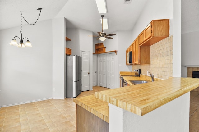 7536 Meadow Creek Dr, Fort Worth, TX 76123 - kitchen featuring freestanding refrigerator, white microwave, a sink, range with electric cooktop, and a peninsula