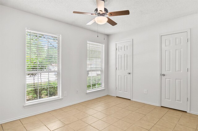7536 Meadow Creek Dr, Fort Worth, TX 76123 - unfurnished bedroom featuring a textured ceiling, light tile patterned floors, and ceiling fan