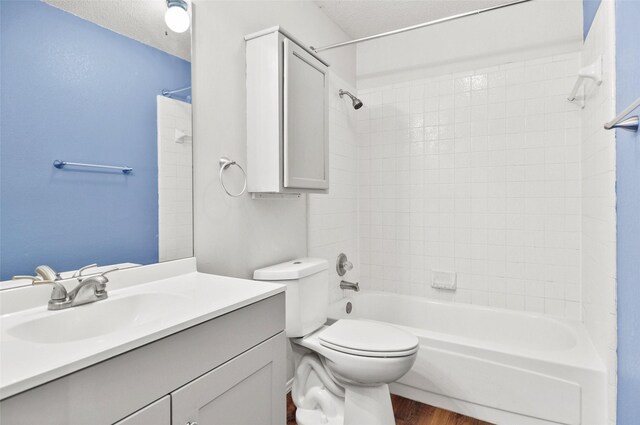 7536 Meadow Creek Dr, Fort Worth, TX 76123 - bathroom featuring tub / shower combination, vanity, wood finished floors, toilet, and a textured ceiling