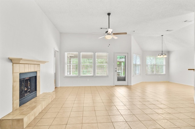 7536 Meadow Creek Dr, Fort Worth, TX 76123 - unfurnished living room featuring plenty of natural light, ceiling fan, a textured ceiling, a fireplace, and a chandelier