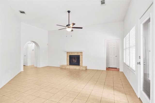 7536 Meadow Creek Dr, Fort Worth, TX 76123 - unfurnished living room featuring a ceiling fan, arched walkways, a fireplace, a high ceiling, and light tile patterned floors