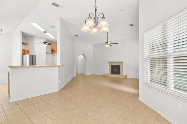 7536 Meadow Creek Dr, Fort Worth, TX 76123 - unfurnished living room featuring ceiling fan, arched walkways, a tile fireplace, a chandelier, and high vaulted ceiling