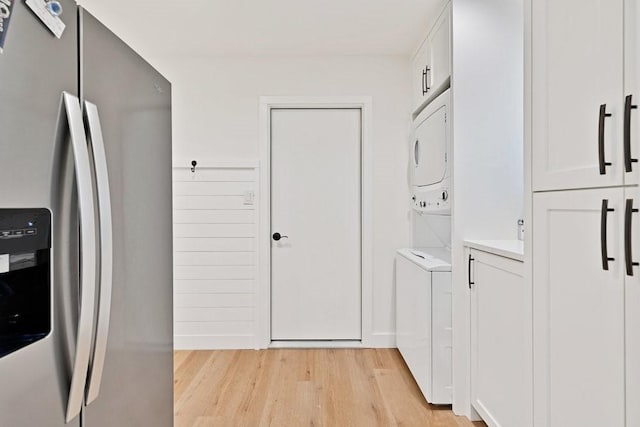 208 E 7th St, Prosper, TX 75078 - laundry room with stacked washing machine and dryer, light wood finished floors, and cabinet space