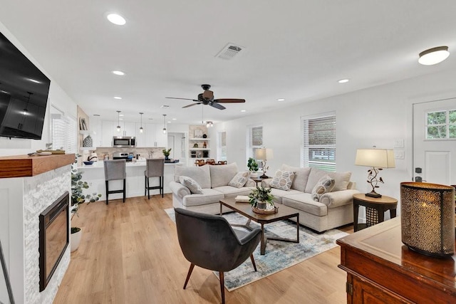 208 E 7th St, Prosper, TX 75078 - living area with light wood-type flooring, ceiling fan, recessed lighting, and a glass covered fireplace