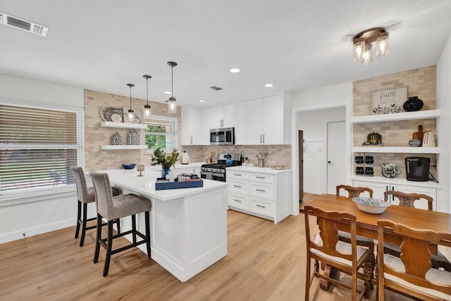 208 E 7th St, Prosper, TX 75078 - kitchen featuring appliances with stainless steel finishes, open shelves, a kitchen breakfast bar, a peninsula, and tasteful backsplash