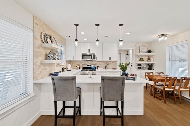 208 E 7th St, Prosper, TX 75078 - kitchen featuring open shelves, appliances with stainless steel finishes, a peninsula, light countertops, and recessed lighting