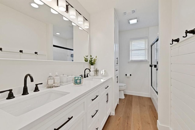 208 E 7th St, Prosper, TX 75078 - full bathroom with toilet, double vanity, wood finished floors, baseboards, and enclosed tub / shower combo