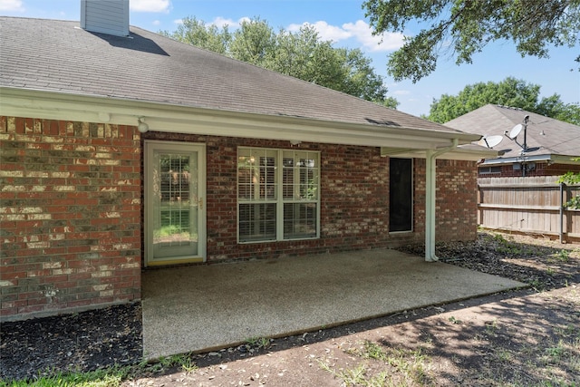2008 Real Dr, Waco, TX 76712 - rear view of house with a patio area, a shingled roof, brick siding, and a chimney