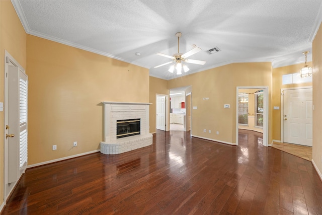 2008 Real Dr, Waco, TX 76712 - unfurnished living room featuring a brick fireplace, a ceiling fan, wood-type flooring, ornamental molding, and a textured ceiling