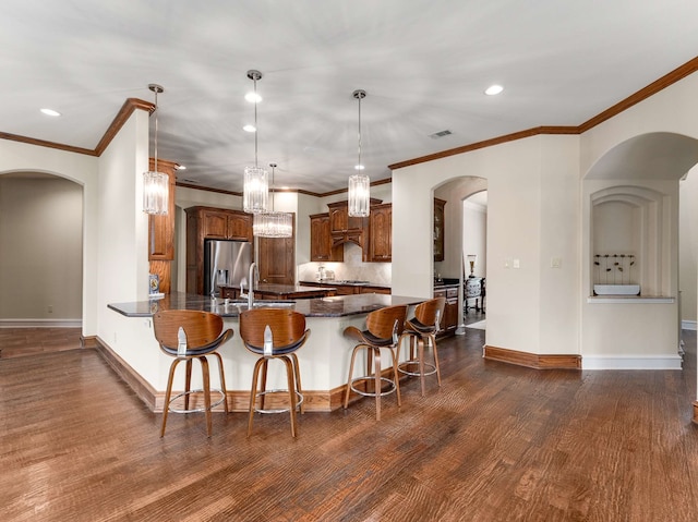 2830 Creekwood Ln, Prosper, TX 75078 - kitchen featuring stainless steel refrigerator with ice dispenser, a peninsula, arched walkways, a breakfast bar, and dark wood-type flooring