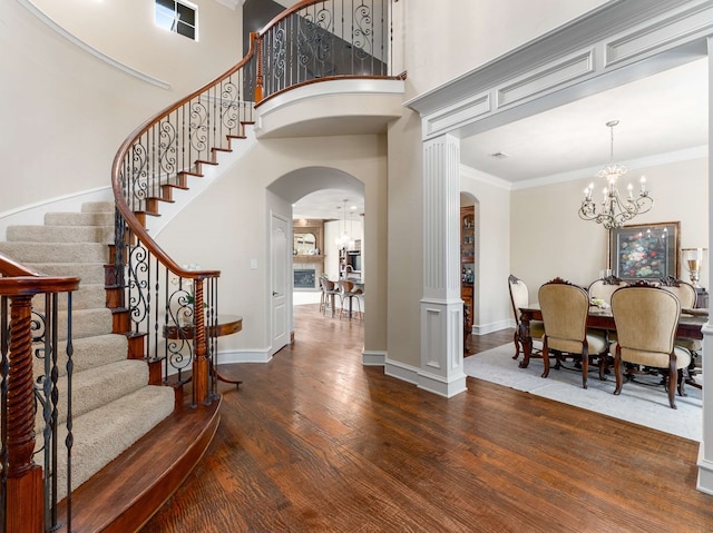 2830 Creekwood Ln, Prosper, TX 75078 - entryway featuring arched walkways, a chandelier, wood finished floors, baseboards, and stairs