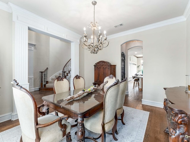 2830 Creekwood Ln, Prosper, TX 75078 - dining space featuring arched walkways, stairway, wood finished floors, crown molding, and a chandelier