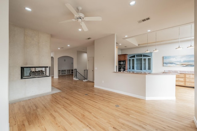 11 Intrepid Cir, Rockwall, TX 75032 - unfurnished living room with recessed lighting, light wood-style floors, a multi sided fireplace, baseboards, and ceiling fan