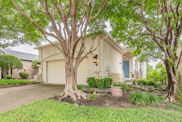 11 Intrepid Cir, Rockwall, TX 75032 - view of front of home featuring stucco siding, a garage, stone siding, and driveway