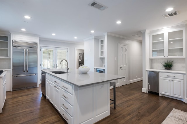 4684 Belclaire Ave, Highland Park, TX 75209 - kitchen featuring stainless steel appliances, a sink, crown molding, estacked washer and dryer, and decorative backsplash