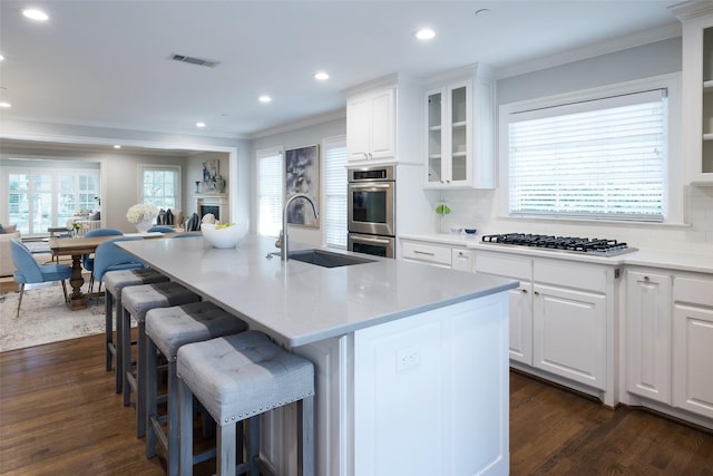 4684 Belclaire Ave, Highland Park, TX 75209 - kitchen with a sink, stainless steel appliances, ornamental molding, dark wood-type flooring, and a breakfast bar