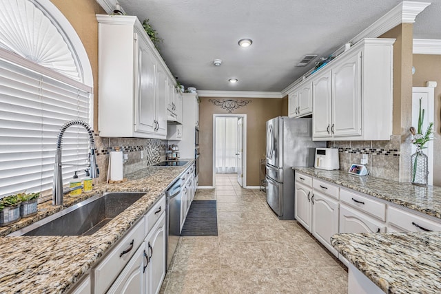 2829 Flint Rock Dr, Fort Worth, TX 76131 - kitchen with a sink, freestanding refrigerator, white cabinetry, crown molding, and tasteful backsplash