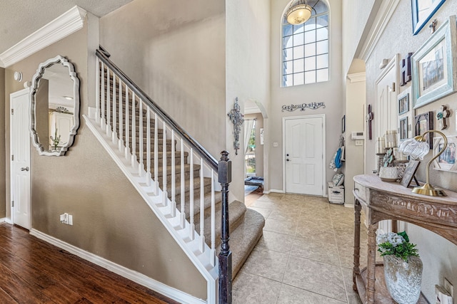 2829 Flint Rock Dr, Fort Worth, TX 76131 - foyer entrance featuring arched walkways, baseboards, crown molding, a high ceiling, and stairway