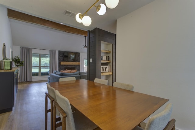1201 Oakhurst Dr, Southlake, TX 76092 - dining space with a fireplace, beam ceiling, ceiling fan, and light wood finished floors