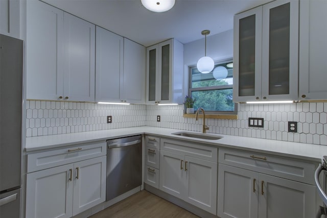 1201 Oakhurst Dr, Southlake, TX 76092 - kitchen featuring stainless steel appliances, a sink, light countertops, light wood-style flooring, and backsplash