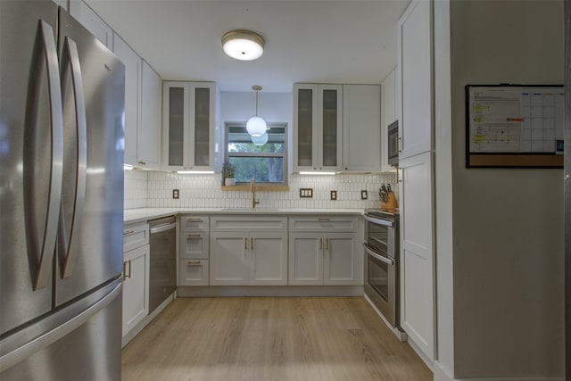 1201 Oakhurst Dr, Southlake, TX 76092 - kitchen featuring stainless steel appliances, a sink, light wood-type flooring, and white cabinetry