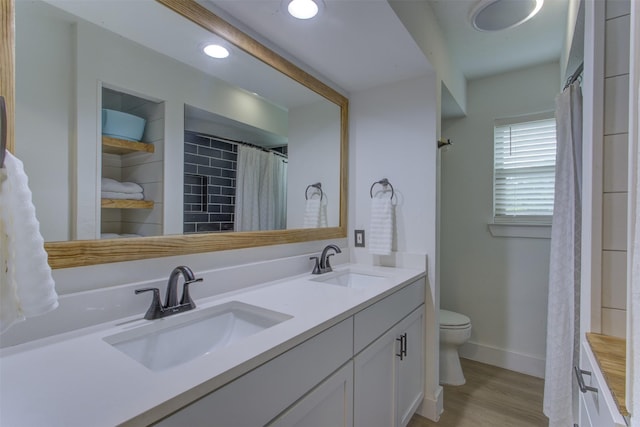 1201 Oakhurst Dr, Southlake, TX 76092 - bathroom featuring double vanity, toilet, wood finished floors, baseboards, and a shower with curtain
