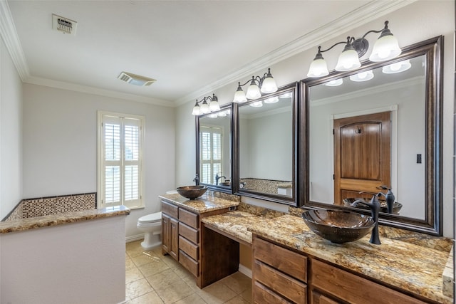 4624 County Road 206, Breckenridge, TX 76424 - bathroom with double vanity, toilet, ornamental molding, and baseboards