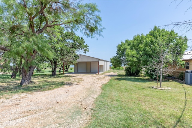 4624 County Road 206, Breckenridge, TX 76424 - view of grassy yard featuring a detached garage, an outbuilding, and dirt driveway