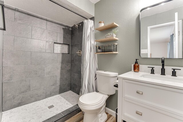 6117 Magnolia Ln, Rowlett, TX 75089 - bathroom with toilet, vanity, wood finished floors, and a tile shower
