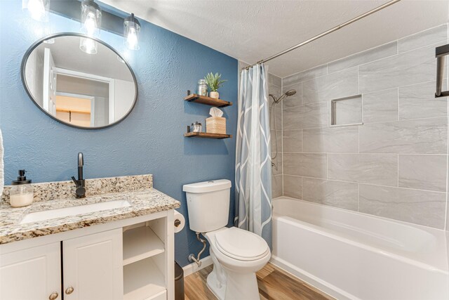 6117 Magnolia Ln, Rowlett, TX 75089 - bathroom featuring wood finished floors, shower / tub combo with curtain, vanity, toilet, and a textured ceiling