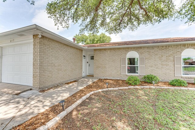 6117 Magnolia Ln, Rowlett, TX 75089 - ranch-style home with a garage and brick siding