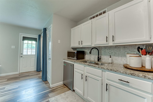 6117 Magnolia Ln, Rowlett, TX 75089 - kitchen with appliances with stainless steel finishes, a sink, baseboards, light wood-style floors, and decorative backsplash
