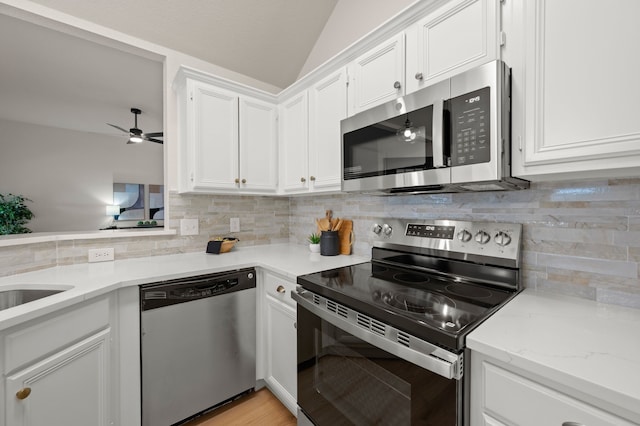 28 Alamosa Dr, Trophy Club, TX 76262 - kitchen featuring appliances with stainless steel finishes, white cabinets, lofted ceiling, backsplash, and a ceiling fan