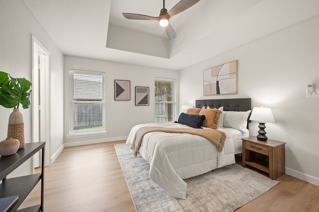 28 Alamosa Dr, Trophy Club, TX 76262 - bedroom with light wood-type flooring, baseboards, a tray ceiling, and ceiling fan