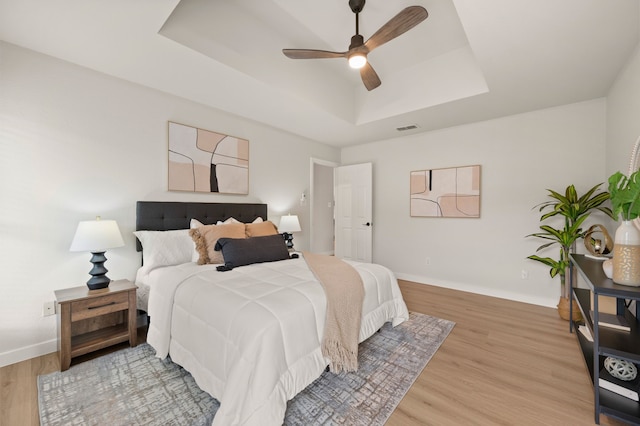 28 Alamosa Dr, Trophy Club, TX 76262 - bedroom with a tray ceiling, light wood-style flooring, baseboards, and ceiling fan