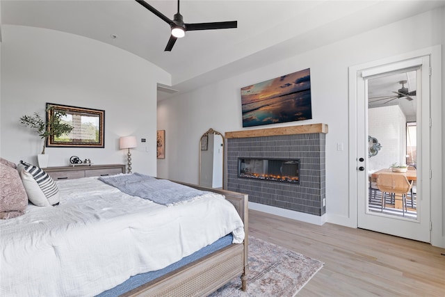 1525 Langford Ln, Celina, TX 75009 - bedroom featuring vaulted ceiling, light wood finished floors, a tiled fireplace, access to exterior, and ceiling fan
