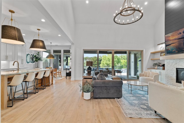 1525 Langford Ln, Celina, TX 75009 - living area with a high ceiling, light wood-type flooring, recessed lighting, a chandelier, and a fireplace