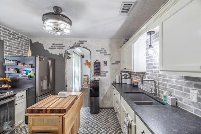 202 E Ross St, Rising Star, TX 76471 - kitchen featuring a sink, stainless steel range with electric cooktop, white cabinets, arched walkways, and ceiling fan