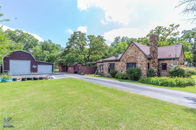 202 E Ross St, Rising Star, TX 76471 - view of front of property featuring stone siding, a detached garage, a front yard, an outdoor structure, and a chimney