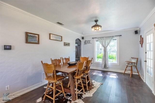 202 E Ross St, Rising Star, TX 76471 - dining space with arched walkways, healthy amount of natural light, crown molding, and dark wood-type flooring