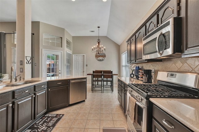 2700 Rochelle Dr, Mckinney, TX 75070 - kitchen with appliances with stainless steel finishes, vaulted ceiling, decorative backsplash, light tile patterned flooring, and a chandelier